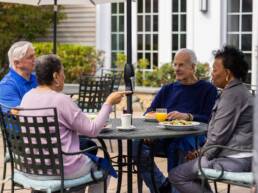 adults sitting at an outdoor table on a patio